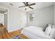 Cozy bedroom with a ceiling fan, hardwood floors, a white bed, and a window at 3285 S Delaware St, Englewood, CO 80110