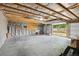 Spacious garage featuring an open door, wood beam ceiling, and ample storage area at 3285 S Delaware St, Englewood, CO 80110