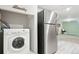 Laundry area equipped with a washing machine and stainless steel refrigerator at 3285 S Delaware St, Englewood, CO 80110