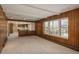 A bright living area with wood-paneled walls and a large window, showing open access to kitchen at 3926 S Magnolia Way, Denver, CO 80237