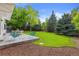 Spacious backyard with lush green lawn, mature trees, and a patio area ideal for outdoor enjoyment at 5853 S Havana Ct, Englewood, CO 80111