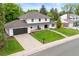 Charming two-story home featuring a well-manicured lawn and a spacious driveway with a modern-looking garage door at 5853 S Havana Ct, Englewood, CO 80111
