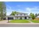 Inviting home with a fresh lawn and a dark-colored garage door, offering a classic yet modern curb appeal at 5853 S Havana Ct, Englewood, CO 80111