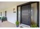 Stylish modern front door with sleek black frame, decorative plants, and a cozy bench on the welcoming porch at 5853 S Havana Ct, Englewood, CO 80111