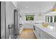 Bright kitchen with a large island, stainless steel appliances, undermount sink, and hardwood floors at 5853 S Havana Ct, Englewood, CO 80111