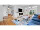 Cozy living area with hardwood floors, featuring a fireplace and blue sofa, with an open layout to the dining area at 5853 S Havana Ct, Englewood, CO 80111