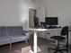 Modern home office with sleek desk, comfortable seating, and adjacent living space with gray sofa at 13788 Umatilla Ln, Broomfield, CO 80023