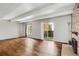 Open living room with hardwood floors, beamed ceilings, and a sliding door to the balcony at 9995 E Harvard Ave # 290, Denver, CO 80231