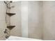 Shower with stone tiling, shelves, and shower head at 9995 E Harvard Ave # 290, Denver, CO 80231