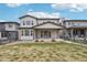 Backyard featuring a well-maintained lawn, stone patio and a covered outdoor space at 1660 Candleflower Dr, Castle Pines, CO 80108