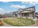 Expansive backyard featuring a lush green lawn, stone patio, and a wooden fence at 1660 Candleflower Dr, Castle Pines, CO 80108