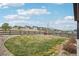 Large backyard with lush green grass, bordered by decorative rocks and a wooden fence at 1660 Candleflower Dr, Castle Pines, CO 80108