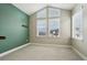 Cozy bedroom with large windows, neutral carpet, and painted accent wall at 1660 Candleflower Dr, Castle Pines, CO 80108