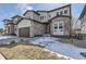 Two-story home showcasing a two-car garage, stone accents, and a well-maintained front yard at 1660 Candleflower Dr, Castle Pines, CO 80108