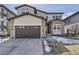 Two-story home showcasing a two-car garage, stone accents, and a well-maintained front yard at 1660 Candleflower Dr, Castle Pines, CO 80108