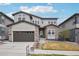 Charming two-story home with stone and siding, showcasing a well-manicured front yard and an attached two-car garage at 1660 Candleflower Dr, Castle Pines, CO 80108