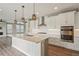 Well-appointed kitchen features stainless appliances, a large center island with quartz countertops, and custom lighting at 1660 Candleflower Dr, Castle Pines, CO 80108