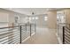 Spacious loft area with modern railing, neutral carpet, and an abundance of natural light from multiple windows at 1660 Candleflower Dr, Castle Pines, CO 80108