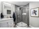 Modern bathroom showcasing a tiled shower with glass enclosure and a sleek vanity with a stylish mirror at 8712 W 64Th Way, Arvada, CO 80004