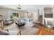 Bright living room featuring hardwood floors, a large window, a comfortable sofa, and a view of the staircase at 8712 W 64Th Way, Arvada, CO 80004