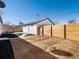 Backyard with wooden fence, gravel landscaping, and a detached white garage with a dark gray door at 4947 Saint Paul St, Denver, CO 80216