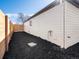 Side view of the backyard with wooden fence, gravel landscaping, and the side of the house at 4947 Saint Paul St, Denver, CO 80216