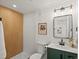 Stylish bathroom featuring wood paneling, white tile, vanity with green cabinets, and modern fixtures at 4947 Saint Paul St, Denver, CO 80216