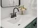 Modern bathroom sink with a black faucet, white countertop, and decorative floral arrangement at 4947 Saint Paul St, Denver, CO 80216