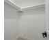 This is an empty walk in closet with white walls and base trim; hanging rod system along the top at 4947 Saint Paul St, Denver, CO 80216