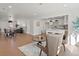 Open-concept living room with wood floors, dining area, seating, and a kitchen with a white island at 4947 Saint Paul St, Denver, CO 80216