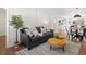 Inviting living room featuring a gray sofa, wood floors, area rug, and a view of the dining area at 4947 Saint Paul St, Denver, CO 80216