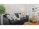 Close up of a gray sofa with decorative pillows and a throw blanket in a brightly lit living room at 4947 Saint Paul St, Denver, CO 80216