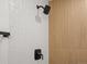 Contemporary shower featuring white tile, wood accent wall, and black hardware at 4947 Saint Paul St, Denver, CO 80216