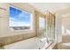 Bathroom with soaking tub, shower, and large window with a view at 7242 E 133Rd Cir, Thornton, CO 80602