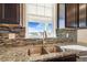 Modern kitchen with granite countertops and a view from the sink window at 7242 E 133Rd Cir, Thornton, CO 80602