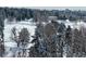 A snowy park with a building in the background and tall snow covered pines at 1200 N Humboldt St # 1406, Denver, CO 80218