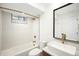 Modern bathroom with stylish geometric tile, bathtub, and elegant vanity with gold fixtures at 863 S Race St, Denver, CO 80209
