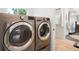 Modern laundry room with stainless steel washer and dryer next to bathroom at 863 S Race St, Denver, CO 80209