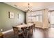 Bright dining room with a wooden table set for six, complemented by a large window offering an outdoor view at 13624 Garfield St # G, Thornton, CO 80602