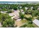 Aerial view of a home with a patio, a fire pit, surrounded by lush greenery, mature trees, and a lake in the background at 8051 S Kendall Blvd, Littleton, CO 80128