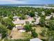 Aerial view of a home with a patio, a fire pit, surrounded by lush greenery and mature trees and a lake in the background at 8051 S Kendall Blvd, Littleton, CO 80128