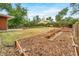 A wide backyard is showcased with garden beds, a patio, a fire pit, and a wooden fence perimeter at 8051 S Kendall Blvd, Littleton, CO 80128