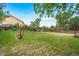 Lush backyard with green grass, wooden fence, fire pit, and beautiful landscaping at 8051 S Kendall Blvd, Littleton, CO 80128