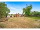 Large backyard featuring a firepit, raised garden beds, a shed, and a fenced perimeter at 8051 S Kendall Blvd, Littleton, CO 80128