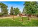 Expansive backyard with patio, mature trees, fire pit, raised garden beds and fenced perimeter at 8051 S Kendall Blvd, Littleton, CO 80128