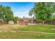 Landscaped backyard view featuring a firepit, shed, mature trees, and wooden garden beds at 8051 S Kendall Blvd, Littleton, CO 80128