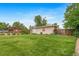 The property features a spacious, well-maintained backyard with lush grass and mature trees, offering privacy at 8051 S Kendall Blvd, Littleton, CO 80128