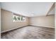Finished basement featuring wood-look flooring, neutral paint, and multiple windows at 8051 S Kendall Blvd, Littleton, CO 80128