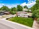 Charming brick home with a well-maintained lawn and driveway, surrounded by mature trees and lush landscaping at 8051 S Kendall Blvd, Littleton, CO 80128