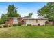 Charming single-story home featuring a well-maintained lawn, mature trees, and a cozy front porch at 8051 S Kendall Blvd, Littleton, CO 80128